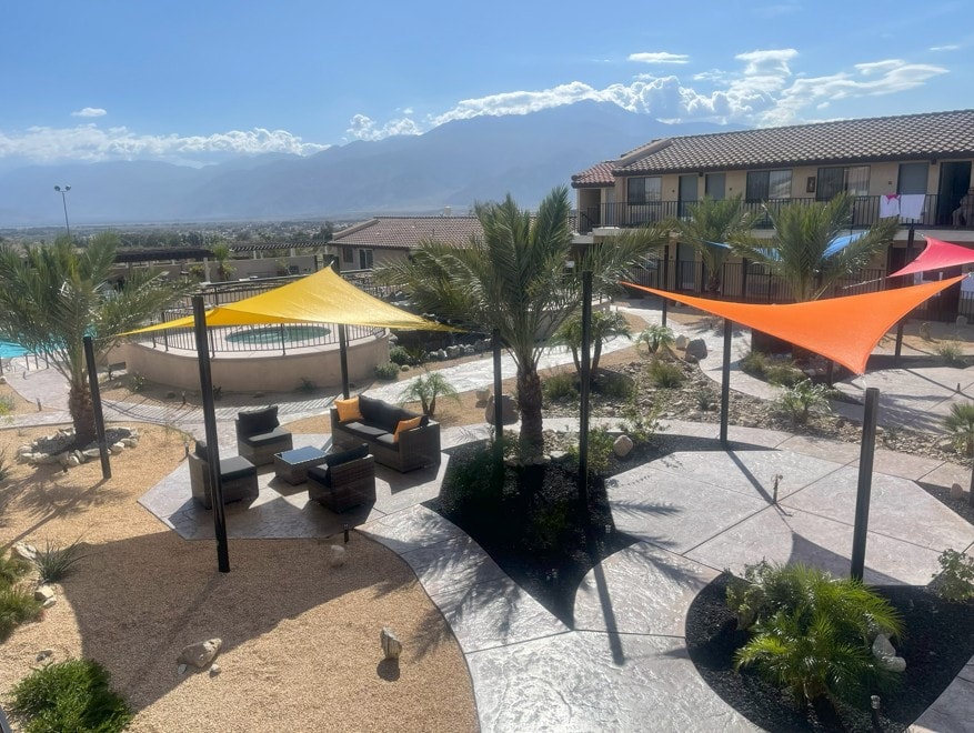 Resort courtyard with colorful shade sails and mountain views